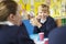 Schoolchildren Sitting At Table Eating Packed Lunch