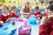 Schoolchildren With Teacher Sitting At Table Eating Lunch