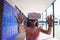 Schoolgirl anticipating while using virtual reality glasses in corridor