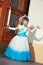 Schoolgirl in blue and white smart dress near the wooden door