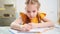 A schoolgirl does her homework. mom sits next to her and helps