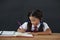 Schoolgirl doing her homework against chalkboard