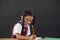 Schoolgirl doing her homework against chalkboard