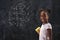 Schoolgirl doing math on blackboard