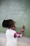 Schoolgirl doing mathematics on chalkboard in classroom