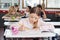 Schoolgirl Drawing In Book At Classroom