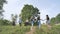 Schoolgirl friends are walking outside the city along a forest road.