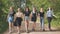 Schoolgirl friends are walking outside the city along a forest road.