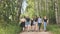 Schoolgirl friends are walking outside the city along a forest road.