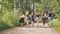 Schoolgirl friends are walking outside the city along a forest road.