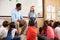 Schoolgirl at front of elementary class with teacher