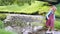 a schoolgirl girl crosses a stream stepping on stones.