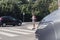 Schoolgirl with headphones and phone on pedestrian crossing in front of a car