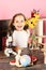 Schoolgirl at her desk with yellow flowers, globe and microscope