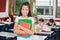 Schoolgirl Holding Books While Standing At Desk