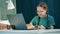 Schoolgirl learning online at home using a laptop