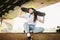 Schoolgirl after lessons at skateboarding practice in outdoor skate park. Stylish and beautiful caucasian girl with skateboard on