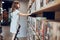 Schoolgirl looking at books on top bookshelf in school library. Smart girl selecting literature for reading. Benefits of everyday