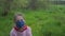 Schoolgirl in mask and gloves plays catching ball in garden