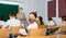 Schoolgirl in mask sitting in classroom