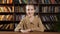 Schoolgirl model poses sitting at new brown wooden desk