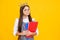 Schoolgirl nerd princess in school uniform and crown celebrating victory on yellow background. School child hold book