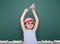 Schoolgirl with paper plane play near a blackboard, empty space, education concept