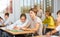 Schoolgirl peeks in a boys notebook during classes in school class