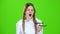 Schoolgirl in a plaid skirt takes off her glasses and yawns . Green screen