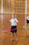 Schoolgirl playing with hula hoop in school gym