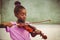 Schoolgirl playing violin in classroom