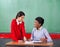 Schoolgirl Pointing On Paper While Teacher Looking