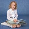 Schoolgirl reading book sitting on floor