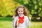 Schoolgirl in school uniform showing thumbs up in the park.