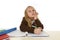 Schoolgirl in school uniform sitting at studying desk doing homework looking thoughtful and absent mind