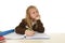 Schoolgirl in school uniform sitting at studying desk doing homework looking thoughtful and absent mind