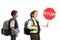 Schoolgirl and schoolboy wearing safety vests and holding a stop sign