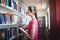 Schoolgirl selecting book from book shelf in library