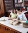 Schoolgirl Showing Book To Classmate In Library