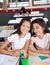 Schoolgirl Sitting With Classmate At Desk In