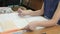 Schoolgirl sitting at desk flips pages of book