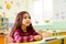 Schoolgirl sitting at her desk in empty classroom