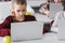 schoolgirl sitting near laptop and apple