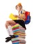 Schoolgirl sitting on pile of books.