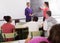 Schoolgirl solves task near blackboard in classroom mathematics