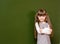 Schoolgirl standing in class near a green blackboard