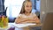 Schoolgirl studies online using a modern laptop. Homework