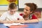 Schoolgirl Studying In Classroom With Teacher