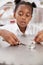 Schoolgirl taking part in a science test, vertical