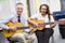 Schoolgirl and teacher playing guitar